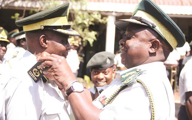 Zimbabwe Prisons and Correctional Services Commissioner-General Retired Major-General Paradzai Zimondi (right) confers new badges and rank to Deputy Commissioner-General Dr Alford Mashango Dube at a ceremony in Harare yesterday. - (Picture by Justin Mutenda)