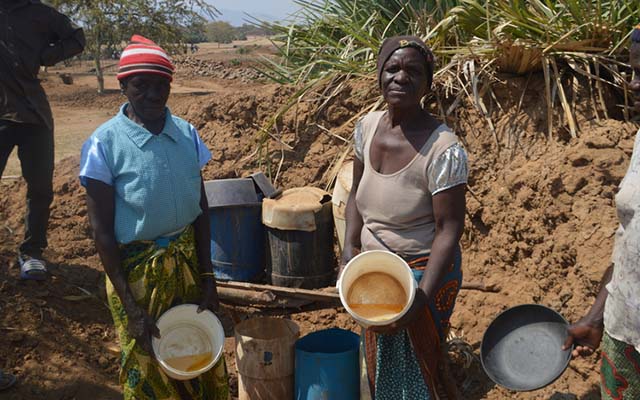 Mbuya Liza Bote and Sarah Mashonga standing by the filtration system.