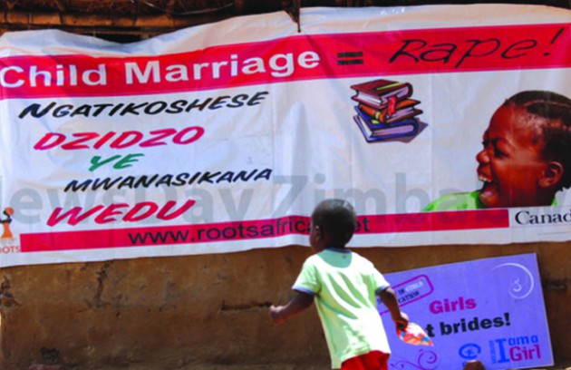 A-child-runs-past-an-anti-child-marriages-poster-at-Case-Farm-in-Shamva-where-ROOTS-was-holding-a-community-dialogue-to-raise-awareness-on-the-dangers-of-marrying-of-children