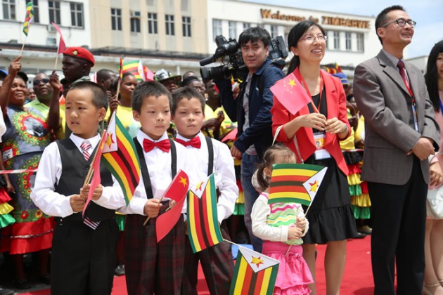 Chinese nationals wait for the arrival of President Xi