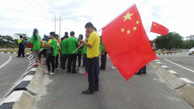 Chinese nationals wait in anticipation of President Xi's arrival.