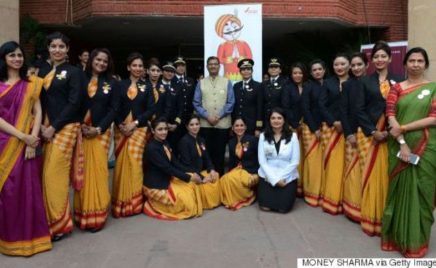 Chairman and Managing Director Air India  Ashwani Lohani (centre) stands with the pilots and crew members of an all-women Air India Delhi - San Francisco - Delhi flight as they pose for a photograph during an event on the eve of International Women’s Day in New Delhi ( Huffington Post Canada)