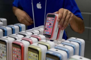 An employee arranges Apple Inc. iPhone 5c and 5s devices during the launch at the company’s new store in Palo Alto. — Bloomberg