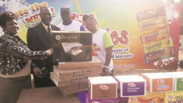 WISE BUY . . . Master Shumba, the headmaster of Kwekwe High in the Midlands, receives five laptops and a printer for being the best buyers for the month