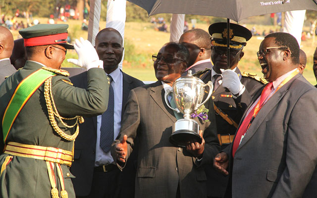 President Mugabe hands over the Best Security Exhibitor trophy to Commander Zimbabwe Defence Forces General Constantino Chiwenga at the Harare Agricultural Show yesterday. - (Picture by Tawanda Mudimu)