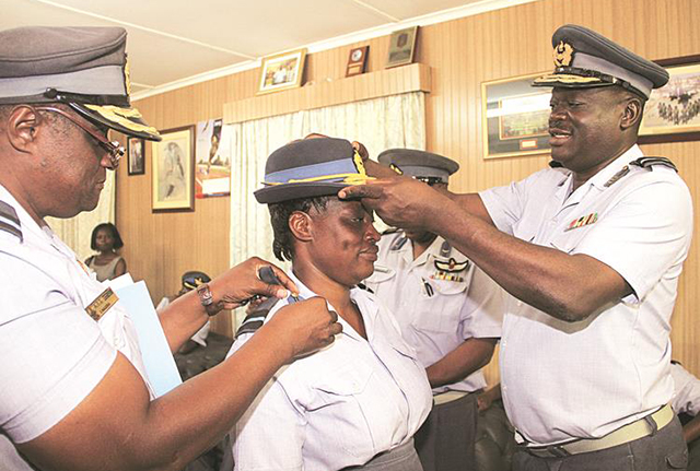 Air Force of Zimbabwe Commander Air Marshall Perrance Shiri (right) confers Air Commodore Ellen Chiweshe with her new rank at Air Force Headquarters in Harare yesterday, while Air Commodore Selebale Masera assists. — (Picture by Tawanda Mudimu)
