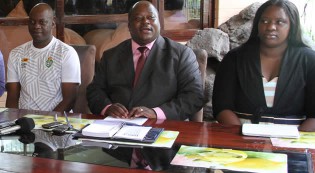 BREAKING THE ICE . . . Sport, Arts and Culture Minister Andrew Langa (centre) unveils Government’s financial package for the Warriors while his deputy Tabitha Kanengoni-Malinga (right) and Ian Gorowa follow proceedings during yesterday’s luncheon in Harare
