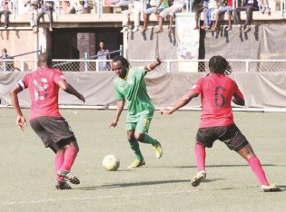ONE WARRIOR, TWO MAMBAS . . . Zimbabwe midfielder Peter “Rio” Moyo lines up his shot while watched by Mozambican defenders, Manuel Uetimaine and Dario Khana, during the World Cup qualifying match at Rufaro yesterday