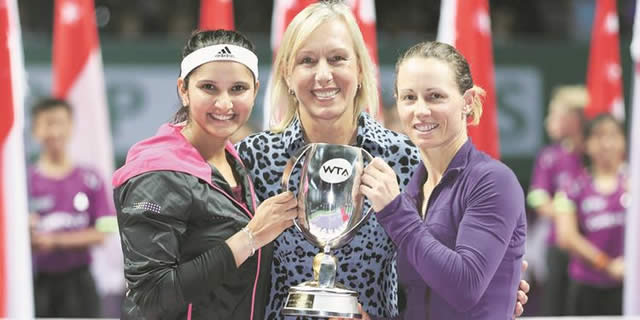 PODIUM OF CHAMPIONS . . . Zimbabwe’s Cara Black (right) and her Indian partner Sania Mirza (left) are all smiles as they receive the BNP Paribas Finals trophy from women’s tennis legend Martina Navratilova after they needed just 59 minutes to defeat defending champions Hsieh Su-Wei and Peng Shuai 6-1, 6-0 in the doubles final in Singapore yesterday