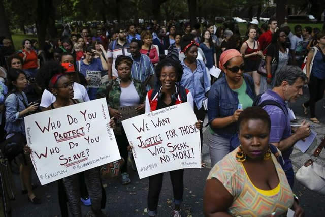 Above, Ferguson, Missouri, residents hold a vigil for slain teenager Michael Brown