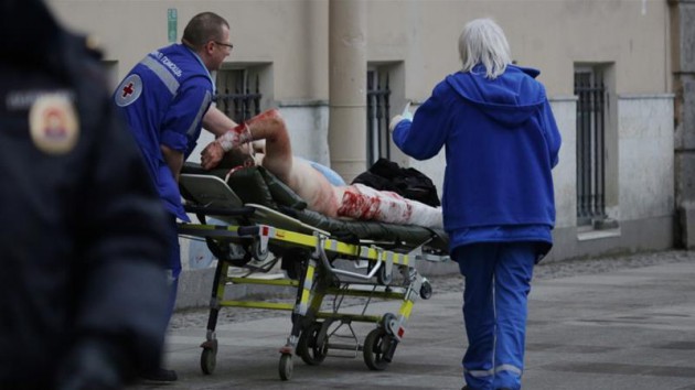 Blast1: A wounded man is helped by emergency services outside a St. Petersburg metro station. - Anton Vaganov/Reuters