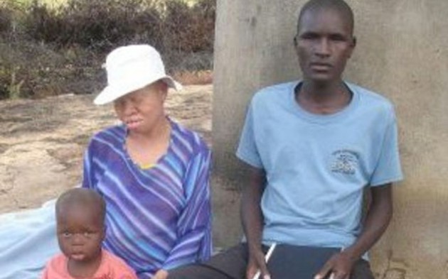 LOVE CONQUERS ALL  . . . Adonia and Janet relax outside their homestead with the younger of their two kids
