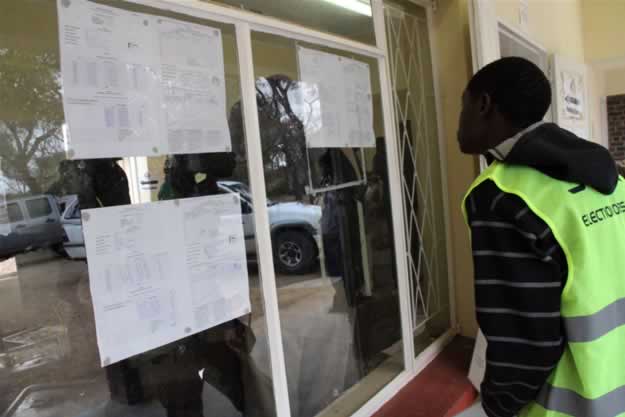 Buhera residents read through stats displayed outside a polling station in Buhera West constituency.