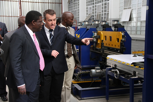 Industry and Commerce Minister Mike Bimha is shown around the new Capri fridge manufacturing factory by Capri managing director Mr Gary Watson