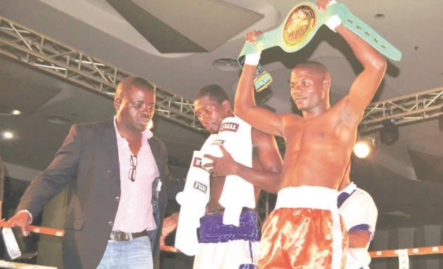 HAIL THE CHAMPION . . . Charles Manyuchi (right) lifts the WBC title belt he retained after making short work of Deivis Casseres of Colombia (in blue trunks) in his defence bout on Saturday night in Lusaka, Zambia. On the far left is Christopher Malunga, the Oriental Quarries Boxing Promotions operations director