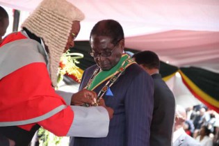 Chief Justice Godfrey Chidyausiku swears President Mugabe during the inauguration at National Sports Stadium