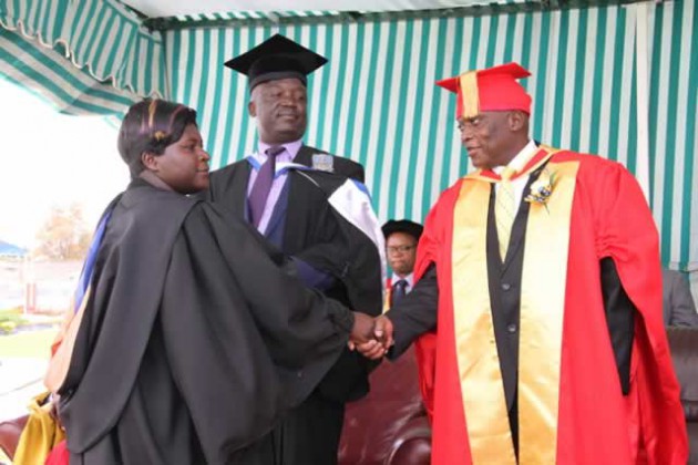 Police Commissioner-General Dr Augustine Chihuri (right) hands over a certificate to Ever Mhiripiri during a police graduation ceremony, while Commissioner Wonder Tembo looks on at Morris Depot in Harare yesterday. - (Picture by Innocent Makawa).