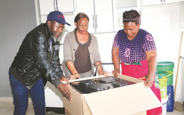 Cde Joseph Chinotimba’s wife Mrs Sostina Chinotimba (centre), hands over a donation of a four plate electric stove to Cde Dickson Chingaira’s wife Patricia Simon Makoni with the assistance of her husband in Harare yesterday. — (Picture by Memory Mangombe)