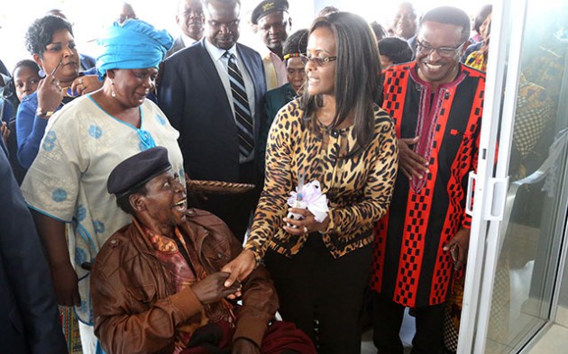 First Lady Amai Grace Mugabe greets an elated Cde Dickson “Chinx” Chingaira at a ceremony where she handed over to him a house built in recognition of his contribution to the country’s independence by the Zimbabwe Music Awards. Looking on is Zima chairperson Mr Joseph Nyadzayo