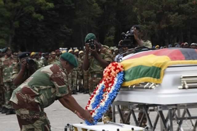 Zimbabwe Defence Forces Commander General Constantine Chiwenga lays a wreath on the casket bearing the body of Brigadier-General Misheck Tanyanyiwa, while the deceased’s widow is comforted by army personnel at One Commando Barracks in Harare yesterday