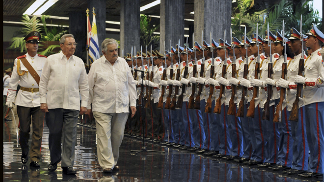 Cuba's President Raul Castro, left, and Uruguay's President Jose Mujica review the honor guard during a welcoming ceremony at Revolution Palace in Havana, Cuba. - (AP Photo/Ernesto Mastrascusa, Pool)