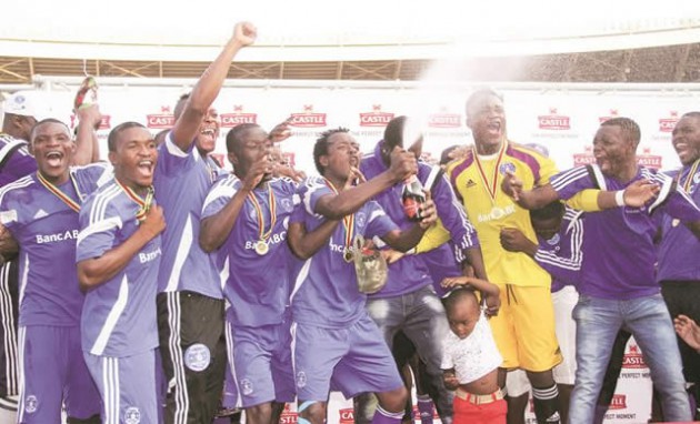 CHAMPAGNE TIME . . . Dynamos players pop a bottle of champagne as they celebrate yet another championship title at the National Sports Stadium yesterday