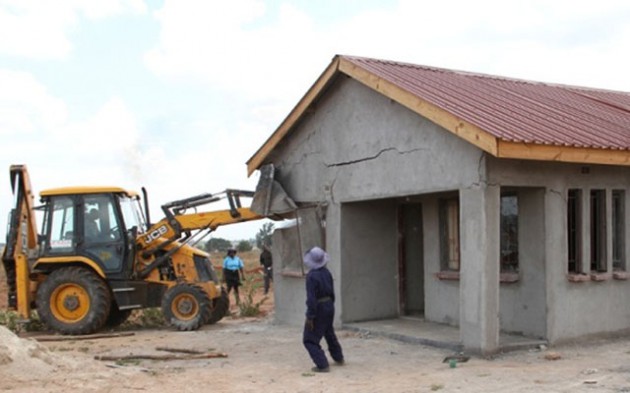 A bulldozer destroys a house at an illegal settlement along Airport Road in Harare last year