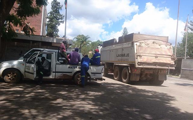 Haulage trucks clearing rubble seen getting into Ziscosteel plant yesterday. Redcliff employees working on water valves at the company yesterday