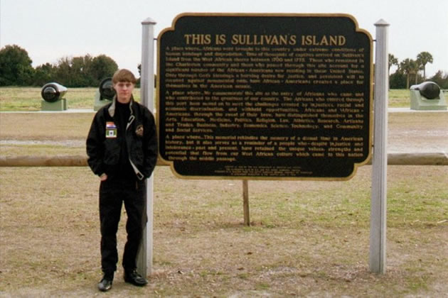 Dylann Roof wearing the jacket with flag patches stands beside a sign at Sullivan’s Island in South Carolina. The island is famous for being the disembarking port for over 40 percent of the estimated 400 000 slaves transported from Africa. It was the largest slave port in North America. Inset are Flag patches on Roof’s jacket. — New York Daily News