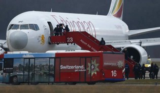 Police evacuate passengers yesterday from the Ethiopian Airlines flight en route to Rome, which was on hijacked and forced to land in Geneva, where the hijacker has been arrested, police said. - AFP