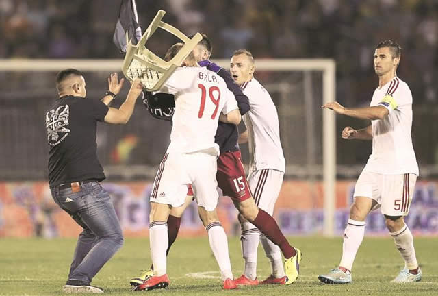 FREE FOR ALL . . . Albania forward Bekim Balaj is struck by a chair thrown by a Serbian fan as tensions boiled over during the Euro 2016 soccer qualifying clash on Tuesday night. — Mailonline