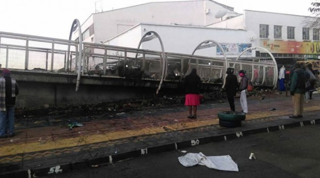 People take a look at the burnt remains of the goods.