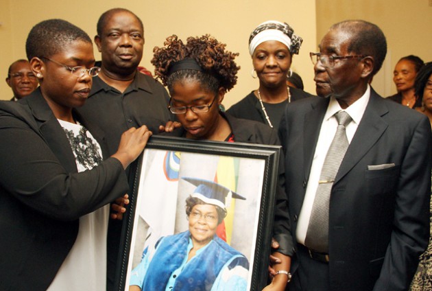President Mugabe and First Lady Amai Grace Mugabe, Professor Jameson Kurasha, husband to the late Zimbabwe Open University Vice Chancellor Professor Primrose Kurasha and daughters Primrose (left) and Flora hold their mother's portrait during a visit by the First Family to console relatives of the late in Avondale, Harare on Saturday.-(Picture by Tawanda Mudimu)