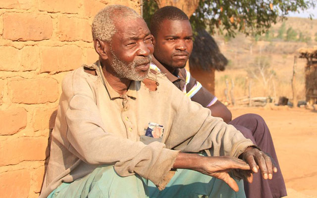 Godfrey Guzuzu (left) and his grandchild Shadreck at their homestead in Guruve. — (Picture by Munyaradzi Chamalimba)