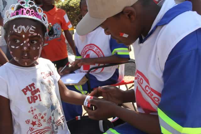 A Red Cross official (above) tags a child for tracking purposes while below a man inspects some of the state-of-the-art machinery on display at the Exhibition Park during the Harare Agricultural Show