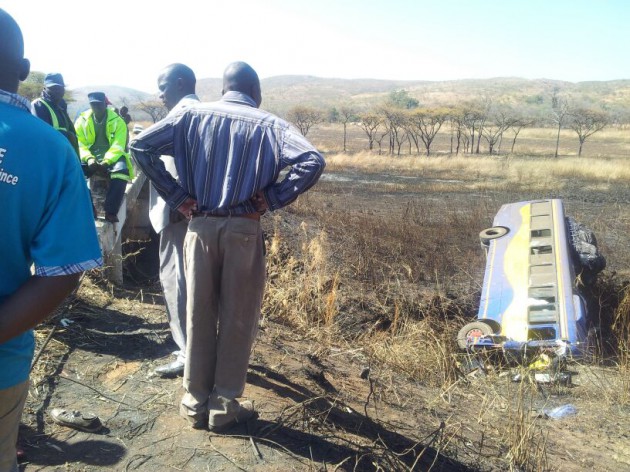Passersby take a look at the wreckage of the Zupco bus while police keep guard on site. (Pic by Elita Chikwati)
