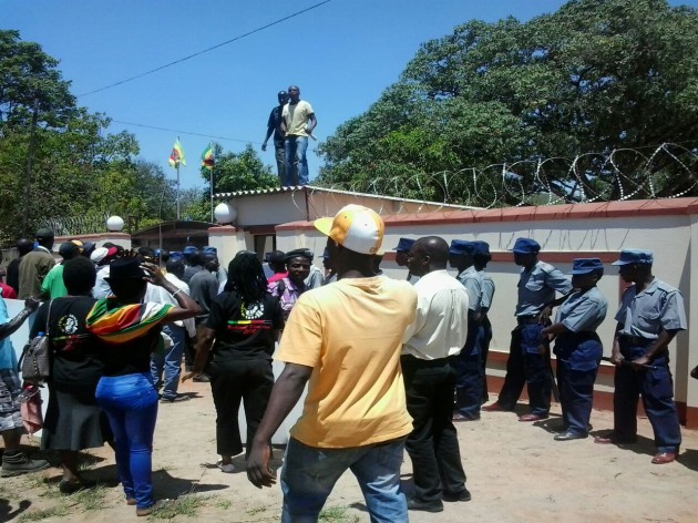 Some youths climb on top of the guardroom at the party headquarters in an attempt to gain entrance. Pic by Farirai Machivenyika.