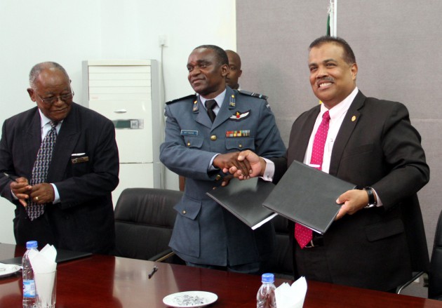 National Defence University Commandant Air Vice Marshal Michael Tedzani Moyo(centre) exchange files with University Utara Malaysia (UUM) Vice-Chancellor, Prof Dato' Seri Dr Mohamed Mustafa Ishak while Ambassador Andrew Mtetwa looks on after a signing ceremony at National Defence University in Harare yesterday.-(Picture by Tawanda Mudimu)