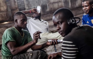 Young unemployed men play cards in an abandoned warehouse in Conakry. — Irin