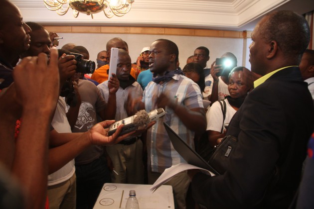 Tawanda Nyambirai (L) is confronted by angry journalists.