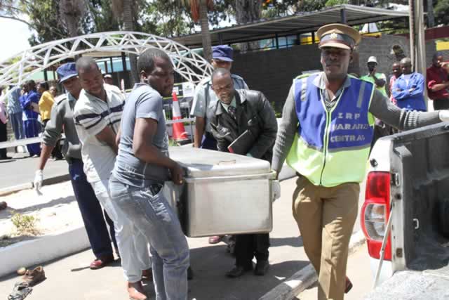 Police Officers carry the body of Justine Janhi which was taken to Milton Park Police station.