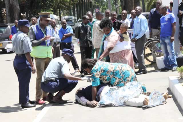 The body of Justin Janhi who collapsed at Zinnara House at the Harare Agricultural Showground on his return to collect papers, being inspected by his wife and relatives.