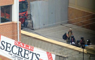 Foreign forensic experts, flanked by Kenyan military personnel, check the perimeter walls around Westgate shopping mall in Nairobi September 25, 2013. – Reuters.