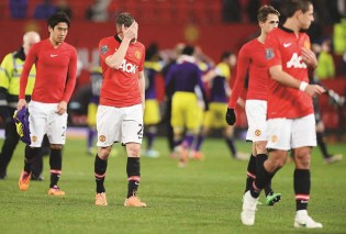 Manchester United’s English midfielder Tom Cleverley (2-L) reacts as he leaves the pitch after the English FA Cup third round football match between Manchester United and Swansea City