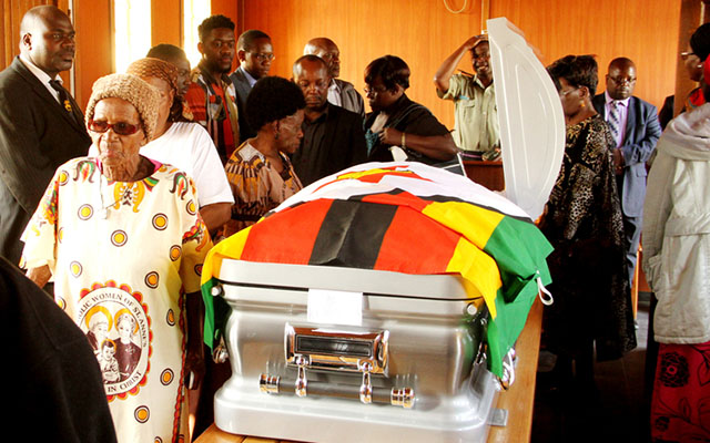 Senator Tsitsi Muzenda (black hat) and relatives view the body of national heroine Cde Maud Muzenda at One Commando Barracks in Harare, yesterday. —(Picture by Tawanda Mudimu)