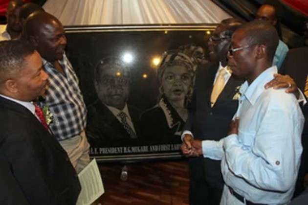 President Mugabe thanks Mr Clemence Maregedze (right) for the portrait of the First Family he made while Deputy Minister of Local Government, Public Works and National Housing Cde Joel Biggie Matiza (left) and Clemence’s father Mr Zvarevashe Maregedze look on in Harare yesterday