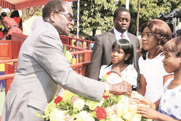 President Mugabe receives flowers as a token of appreciation from Makanaka Saki (left), Moreblessing Svinurai (centre) and Zvikomborero Ndhlovu after he officiated at the Zimbabwe Republic Police 2016 Presidential Graduation Parade at Morris Depot in Harare yesterday. — (Picture by Innocent Makawa)