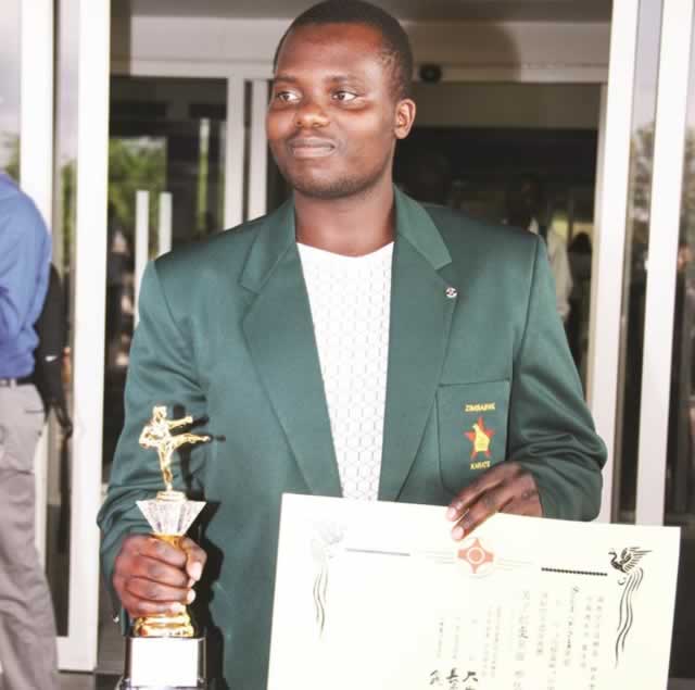 MAKING HIS MARK . . . Naison Chituwa displays his trophy and certificate on arrival at the Harare International Airport yesterday