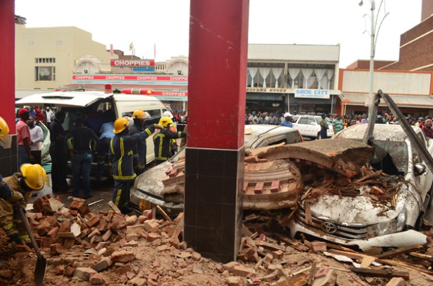 Members of the Bulawayo Fire Brigade clearing the rumble afte part of the Nandos structure collapsed damaging parked vehicles along Jason Moyo Street in Bulawayo yesteday.