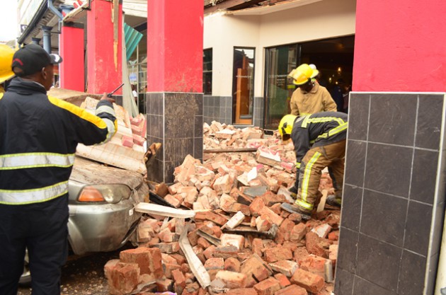 Members of the Bulawayo Fire Brigade clearing the rumble afte part of the Nandos structure collapsed damaging parked vehicles along Jason Moyo Street in Bulawayo yesteday.